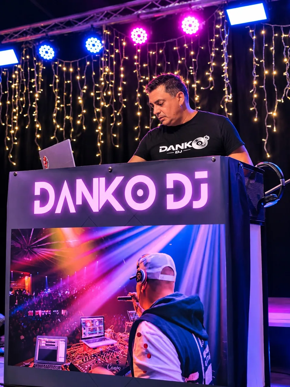 Danko DJ pinchando en cabina bajo focos de colores