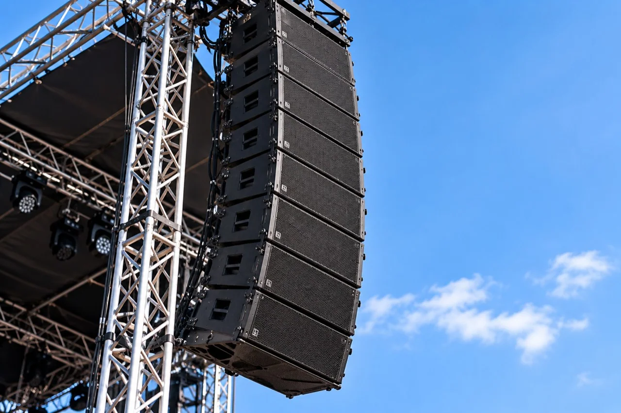 Sistema de sonido line array suspendido en la estructura de un escenario al aire libre